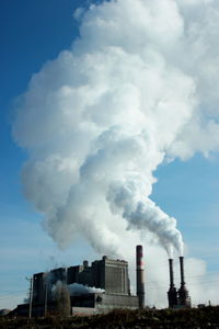 Smoke emitting from chimney against sky