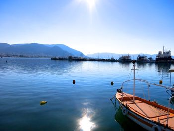 Boats moored in water against sky