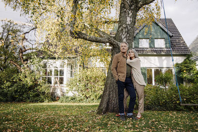 Senior couple in garden of their home in autumn