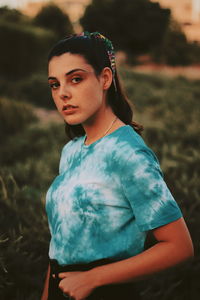 Portrait of a beautiful young woman standing on field