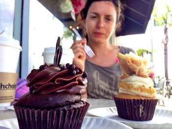 Portrait of woman having cupcakes at outdoor cafe