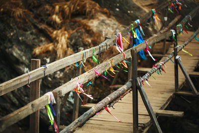 Wooden bridge above mountain river in autumn with traditional buddhism ribbons. nature background.