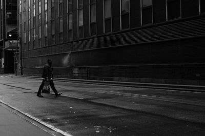 Man walking on footpath in city