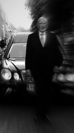 Side view of smiling young woman on car