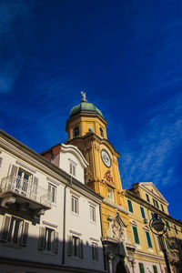Low angle view of building in rijeka against blue sky