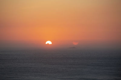 Scenic view of sea against romantic sky at sunset