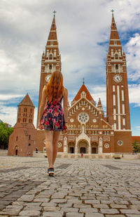 Rear view of woman against building in city