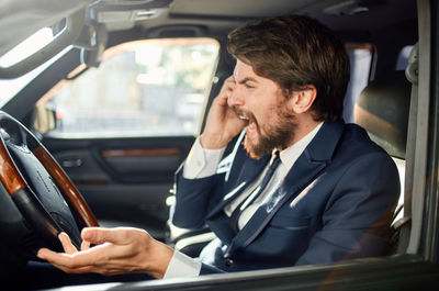 Businesswoman using mobile phone while sitting in car