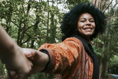 Portrait of smiling young woman in forest