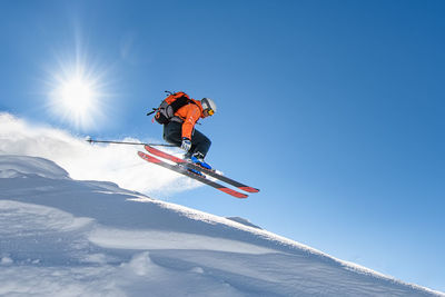 Low angle view of woman skiing on snow covered landscape