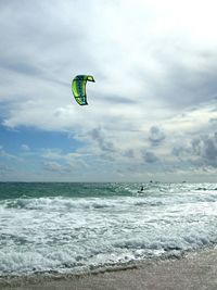 Distant view of man kiteboarding in sea