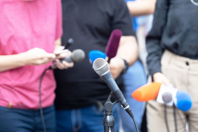 Midsection of man holding camera while standing outdoors