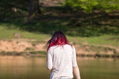 Rear view of woman standing against lake