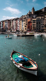 Boats moored in canal by buildings in city