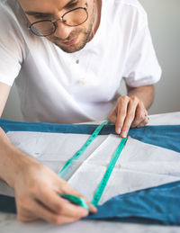 A self-taught seamster in white t-shirt  works with fabric, pattern and chalk. hobby, small business