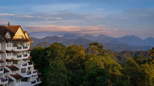 Scenic view of townscape by mountains against sky