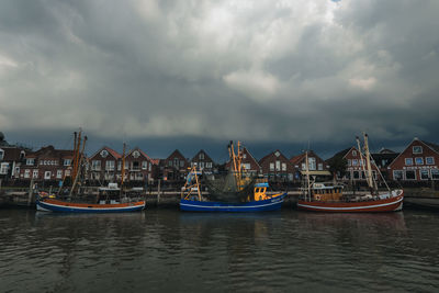 Sailboats moored in sea against sky