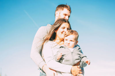 Happy family against sky during summer