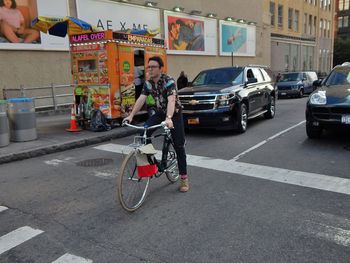 Man riding bicycle on street in city