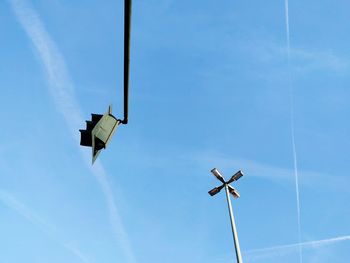 Low angle view of floodlight and road signal against sky