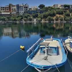 Boats moored in lake against buildings