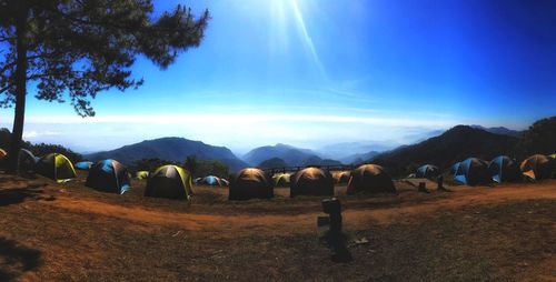 Hay bales on field against blue sky