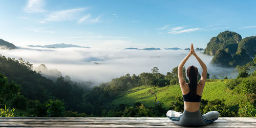 Full length of senior woman against trees and mountains against sky