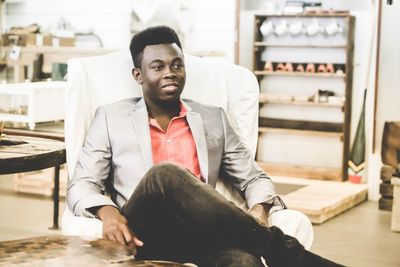 Portrait of man sitting in lounge chair indoors