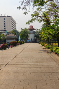 Footpath amidst buildings against sky