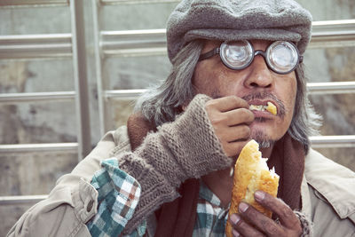 Man looking away while eating food