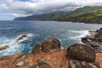 Scenic view of sea and mountains against sky