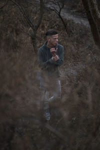 Man standing amidst trees in forest