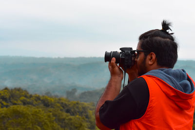 Close-up of photographer photographing through camera