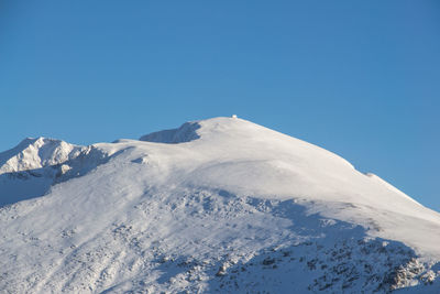 Scenic view of snowcapped mountains against clear blue sky