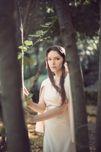 Portrait of fairy elf young woman standing by trees