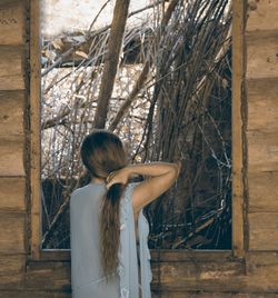 Rear view of woman standing by tree