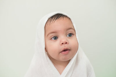 Cute boy looking away against white background