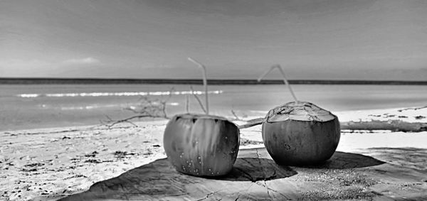 Close-up of deck chairs on beach against sky