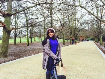 Portrait of smiling young woman standing in park