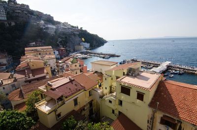 High angle view of houses by sea against sky