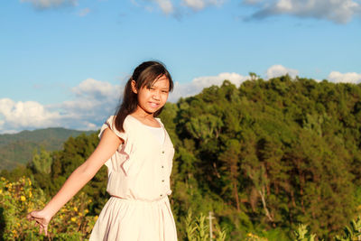Portrait of smiling young girl standing against mountain
