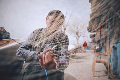 Man cutting fishing net in city