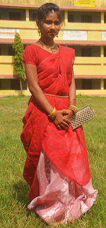 Young woman holding red while standing on field