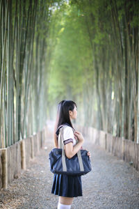 Full length of woman standing on footpath