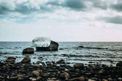 Scenic view of sea against cloudy sky during winter