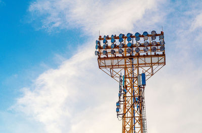 Stadium spotlight set on background of blue sky.