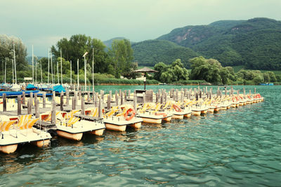 View of boats moored in water against sky