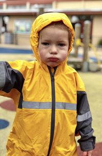 Portrait of boy wearing raincoat while standing outdoors