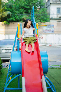 Full length of girl on slide at playground