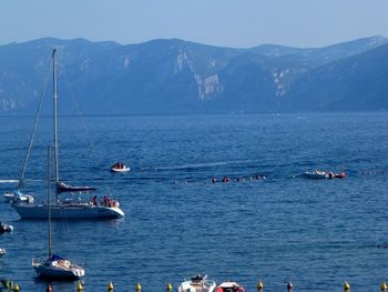 Sailboats in sea against sky